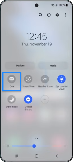 As the onscreen guide shows, pull down the notifications bar on your phone and tap the DeX button.