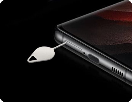 Ejector tool inserted into the SIM and microSD card tray of a Samsung Galaxy phone.