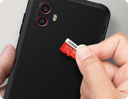 Person inserting a microSD card into the back of a Galaxy XCover6 Pro.