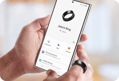 Une main porte une Galaxy Ring et tient un téléphone affichant l'interface de l'application Galaxy Wearable.