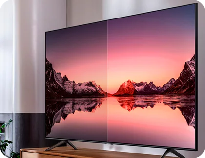 Un téléviseur Samsung affiche un coucher de soleil entre des sommets montagneux, illustrant une profondeur et une clarté des couleurs exceptionnelles grâce à la technologie HDR.