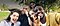 Fünf Menschen lächeln und machen gemeinsam ein Selfie in einem Park.