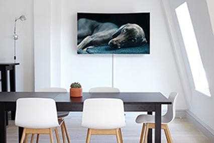 Ein Esszimmer in dem ein Samsung TV an der Wand hängt.