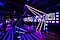 Influencer versammeln sich in der Creators Lounge des Events. Man sieht eine farbenfrohe Lichtershow und im Hintergrund ein DJ-Pult und eine Bar.