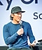 Jimmy Chin trägt eine Baseballmütze und einen blauen Sweater, während er auf der Bühne des Creator Lounge Creators Talk spricht