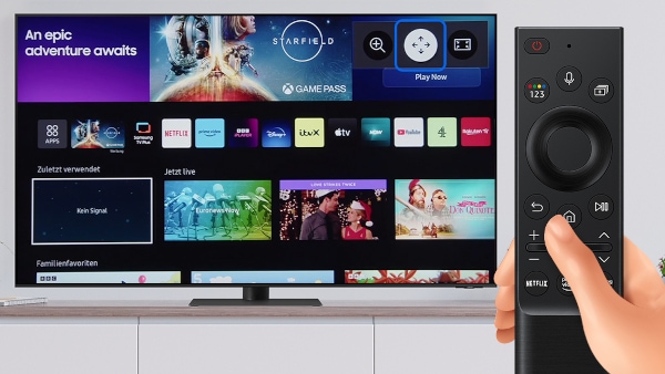 Samsung Smart TV steht auf einem Sideboard. Hand bedient Fernbedienung des Fernsehers, um den Bildschirm-Bereich zu bewegen.
