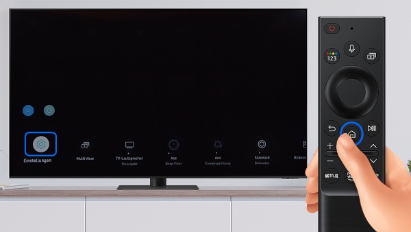 Samsung Smart TV steht auf einem Sideboard. Hand bedient Fernbedienung des Fernsehers. Die Home-Taste der Fernbedienung ist umkreist, sowie die Option Alle Einstellungen auf dem Bildschirm des Samsung Smart TVs.