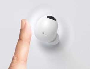 Ein Finger, der auf einen Galaxy Bud tippt.