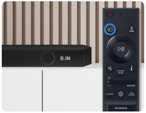 Bild einer Soundbar mit Anzeige des D.IN Modus und einer Smart Remote mit Markierung auf der Quelle-Taste.