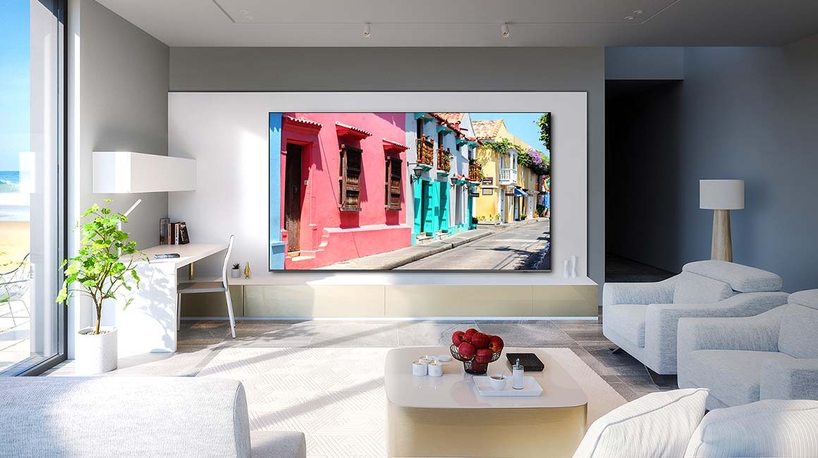 Ein 98-Zoll-Supersize TV ist an der Wand eines Wohnzimmers montiert und zeigt bunte Gebäude an.
