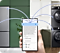 En hånd holder en telefon med SmartThings-appen på skærmen. Telefonen er tilsluttet et Bespoke køleskab, vaskemaskine, opvaskemaskine, støvsuger og klimaanlæg illustreret med blå linjer. AI Energy Mode er aktiveret.