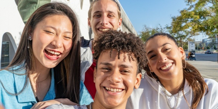 Cuatro estudiantes sonriendo.
