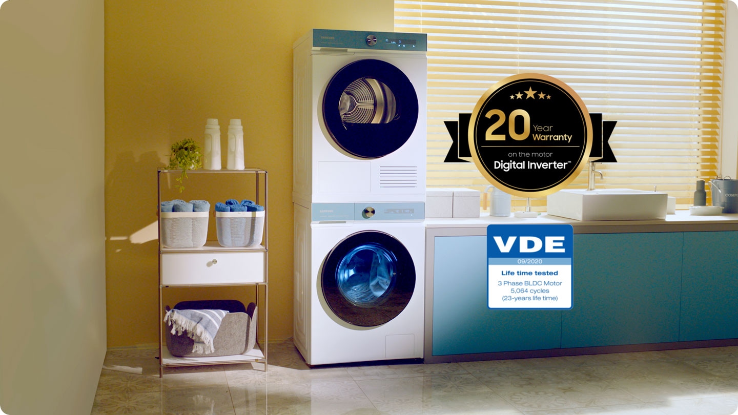 O motor digital inverter da máquina de lavar Bespoke AI™ está a ser montado e colocado outra vez dentro da máquina de lavar roupa. Numa sala colorida e com bastante luz, há uma máquina de lavar e máquina de secar Bespoke AI™ branca com painéis da cor Morning Blue, colocados em conjunto, com uma máquina de secar colocada em cima. Ao lado destas duas máquinas estão dois logótipos de certificação. O primeiro é de 20 anos de garantia ao nível do motor digital inverter. O segundo é o do tempo de vida útil do eletrodoméstico, testado pela VDE, motor BLDC trifásico de 5.064 ciclos e 23 anos.