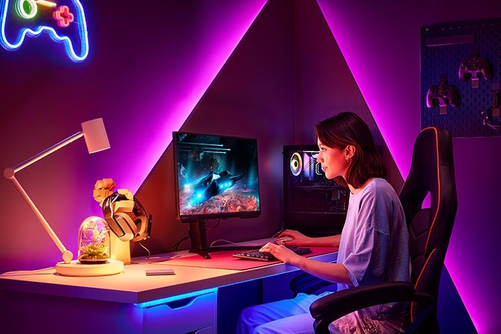 En kvinna spelar ett spel med en Dual QHD Curved monitor.