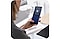 A woman sitting at a desk holding her Galaxy S20 Ultra, which has the Knox Manage interface onscreen