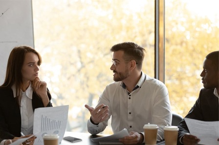 groupe d'une femme et deux hommes échangeant en réunion