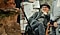 Joe Wright, assis sur une chaise de réalisateur sur un plateau de production, regarde un moniteur en souriant.