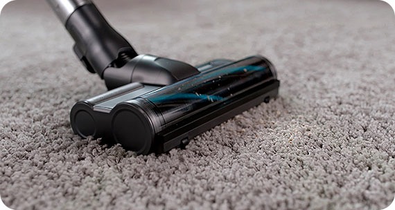 It is cleaning on gray carpet with Samsung Cordless vacuums.