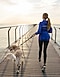 Vue d’une femme de dos qui promène son chien sur un ponton le matin