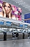 un grand écran de signalisation LED de type L au-dessus du comptoir d'enregistrement du terminal.
