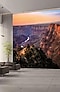 L'écran mural, montrant le paysage de la vallée rouge, exposé dans le hall d'une entreprise avec des canapés près de larges fenêtres à gauche et la réception à droite.