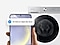 Devant un lave-linge, une main tient un smartphone Galaxy. Il affiche l'interface SmartThings avec une notification pour nettoyer le tambour.