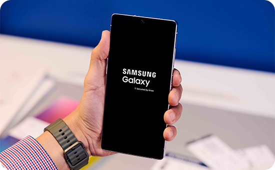 Image d’une main tenant un smartphone Samsung Galaxy en train d’essayer de redémarrer le téléphone