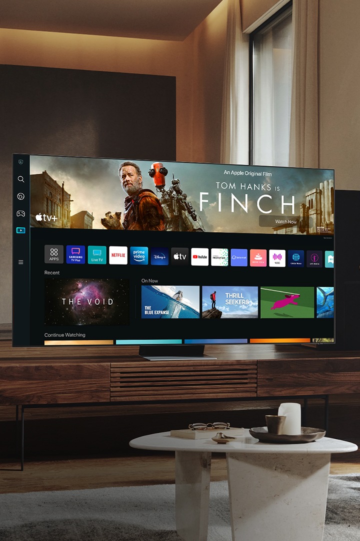 Un homme dans son salon regarde la nouvelle UI Smart TV sur son Neo QLED