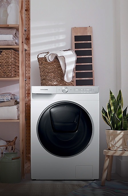 A white Samsung washing machine stood in a utility closet.