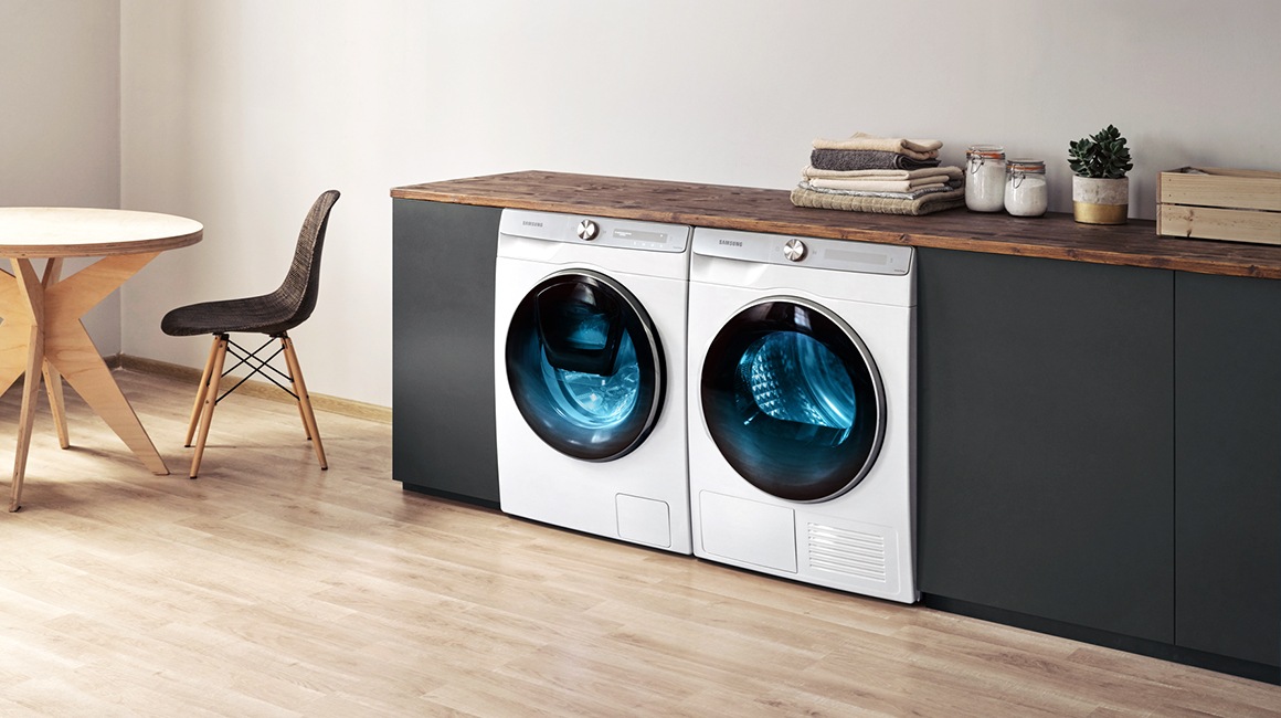 Sous le plan de travail noir se trouve le nouvel ensemble lave-linge et sèche-linge Samsung.