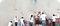 Vemos a personas con camisas blancas que pintan un mural juntas.
