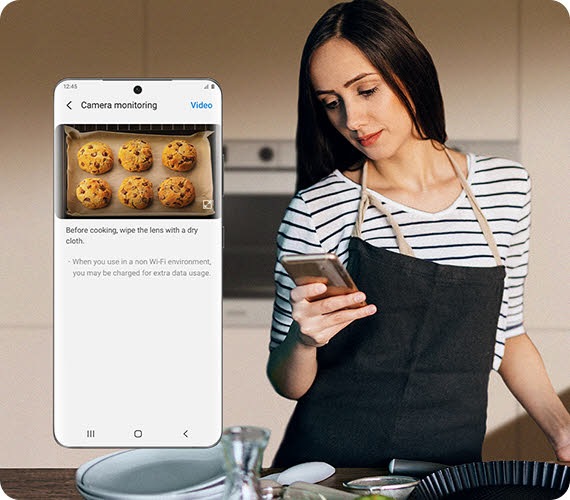Samsung Induction Range's AI Home control panel is at the top, indicating two recipe options: roast sirloin of beef and ratatouille. Below, there is 2 badges; first one is indicating that Sense Inside's AI algorithm is verified for food recognition and burn detection and the other one is verified logo from UL, numbered V346361. Next, there is a woman in the kitchen holding a phone. The magnified view of her phone screen has AI Pro Cooking's camera monitoring tab that features the inside view of the oven as six cookies are baking. Then, a close up of a tray inside the oven appears as a few cinnamon buns bake in fast motion. It then zooms out to reveal that the video of cinnamon buns baking was shared as an instagram post, as indicated by the phone screen thats being held up by a hand.