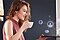 Woman holding her laptop while drinking coffee