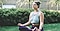 Woman in yoga pose on some grass in a garden