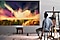 A man sitting in front of a painting next to an easel
