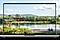 A lake in a park that is seen through the laptop screen