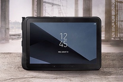 Una tableta Galaxy Tab Active3 se coloca en posición vertical con la pantalla hacia la cámara en una habitación de hormigón a medio construir.