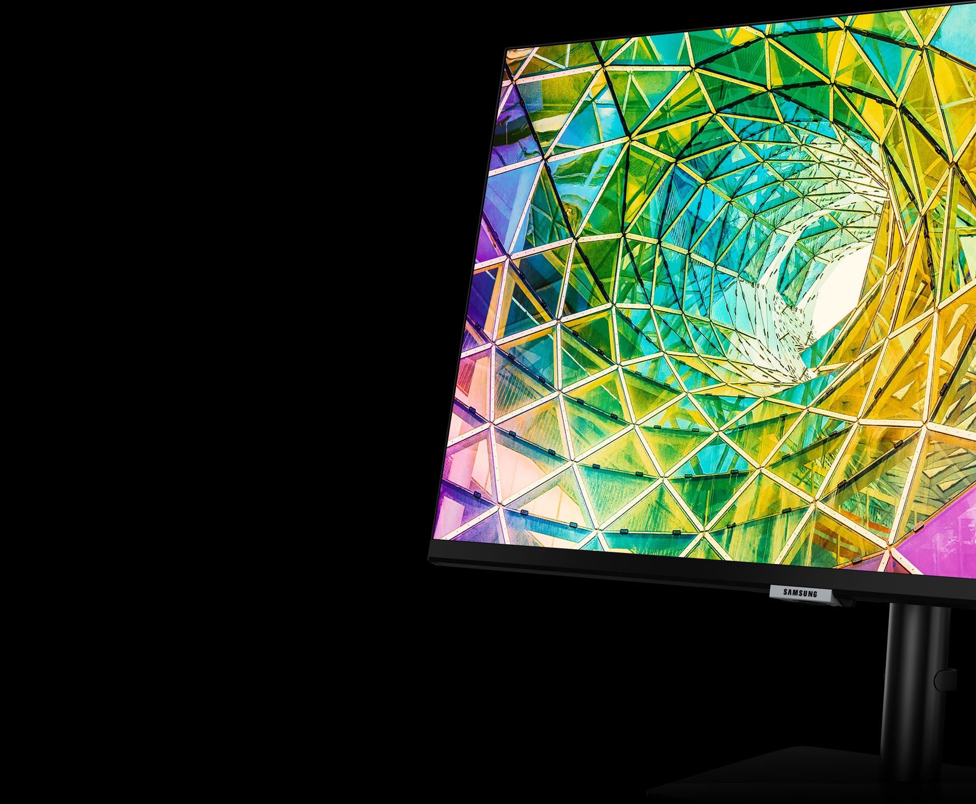 Het monitorscherm toont gedraaid gekleurd glas in felgeel, groen, roze en paars. De monitor wordt naar links gedraaid en iets naar achteren gekanteld met behulp van de schermstandaard.