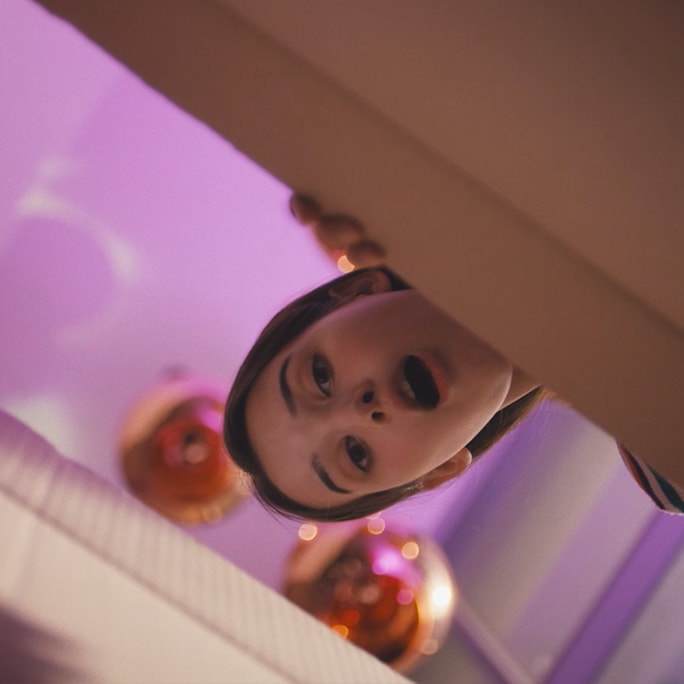 A girl peers down into a box with a surprised expression.