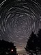 夜空相片展示出長曝效果下緩慢移動的夜空。在單一曝光下,星星在天空中的晚間軌跡被攝下,造成一個散發光芒的效果。前景有松樹。