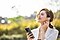 A woman outside listening to music with headphones on to tune into mindfulness