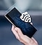 A hand holds up a Galaxy smartphone device that has a glass-like layer floating in front of the screen. A white Samsung Knox logo floats in front of the glass-like layer.