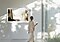 The Frame on the wall is displaying one of Johannes Vermeer paintings, 'Woman with a Pearl Necklace', which makes living room a gallery, and a woman is watching the artwork.
