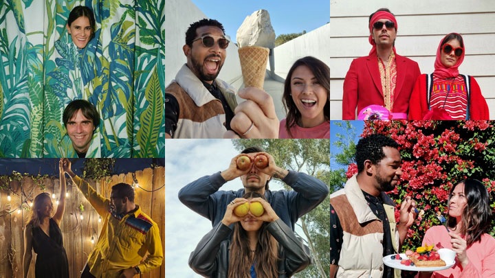 A collage of two couples re-creating various moments in their real love stories. First, a woman and man peeking their faces out from a plant-printed shower curtain. Second, a woman and man taking a selfie at a sculpture garden with their mouths ajar. She is holding an ice cream cone up to the camera while a rock in the background appears to be sitting on top of the cone in the foreground. Third, a man and woman stand, side by side in front of a house. They are both dressed in red and wearing sunglasses and red hair scarves. Fourth, a woman and man strike a dancing pose in front of a fence lined with lit-up string lights. Fifth, a man stands behind a woman in front of a tree-lined backdrop. They are both holding apples up to their eyes like binoculars. And the last, man and woman look at each other in front of a flower bush outdoors. The man is holding a spoon while the woman is holding a fork in one hand and a plate of fruit-topped waffles in the other hand.