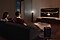 A couple enjoys a movie night in their living room with Samsung Soundbar's theater-like surround sound.