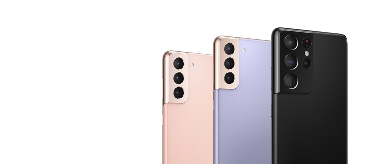 A Phantom Pink Samsung Galaxy S21 5G phone, a Phantom Violet Samsung Galaxy S21+ 5G phone, and a Phantom Black Samsung Galaxy S21 Ultra 5G phone are shown placed side by side, with a focus on the Galaxy S21 5G & Galaxy S21+ 5G devices' triple camera and the Galaxy S21 Ultra 5G device's quad camera.