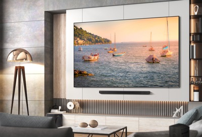 Modern living room with a large Samsung Smart TV displaying a vibrant scene of sailboats on a colorful bay.