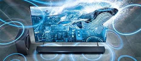 A whale swimming in the sea is coming out of the TV screen. There is a Q-series soundbar, speakers and subwoofer around the TV.