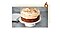 Step 6. The sponge cake is served on a white plate, and roughly chopped whole hazelnuts are scattered over the cake.