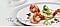 The Recipe : Three pan-seared prawns and a cucumber salad are presented on a white plate.